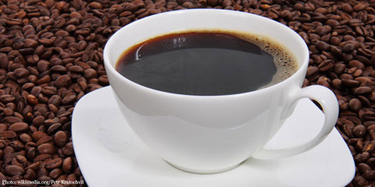 Coffee cup surrounded by coffee beans