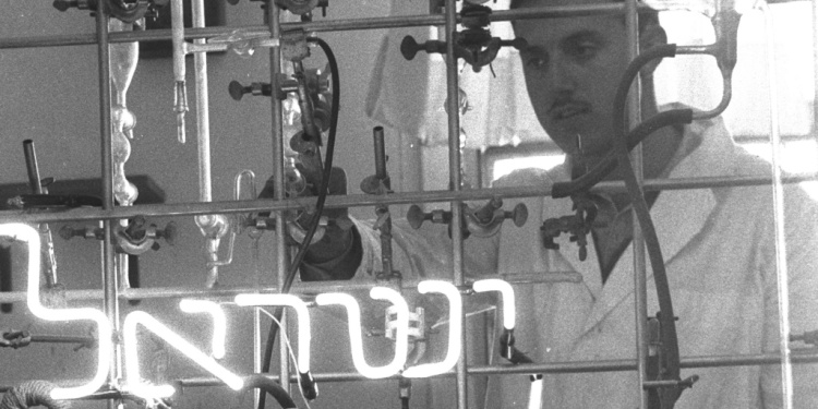 Israeli worker making neon light in glass factory, 1959