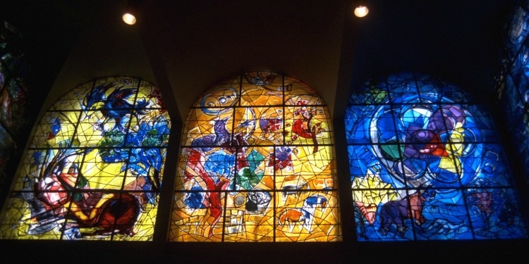 Three stained glass windows inside a large building.
