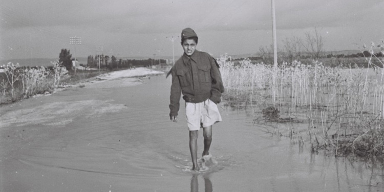 An olim (immigrant) child makes his way through the waters in Israel, 1949.
