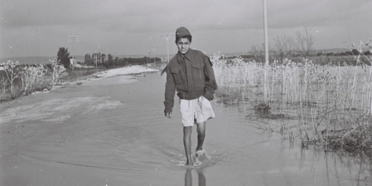 An olim (immigrant) child makes his way through the waters in Israel, 1949.