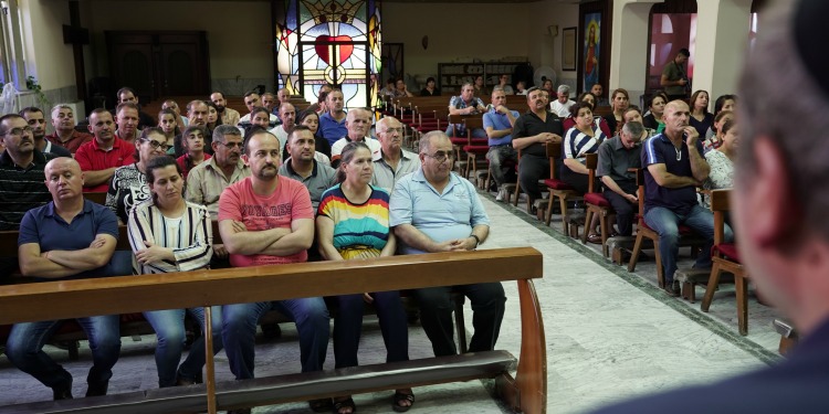 People in church sitting on the pews.