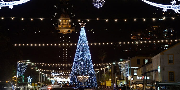 Decorated Christmas trees with a Hanukkah candle in front of them