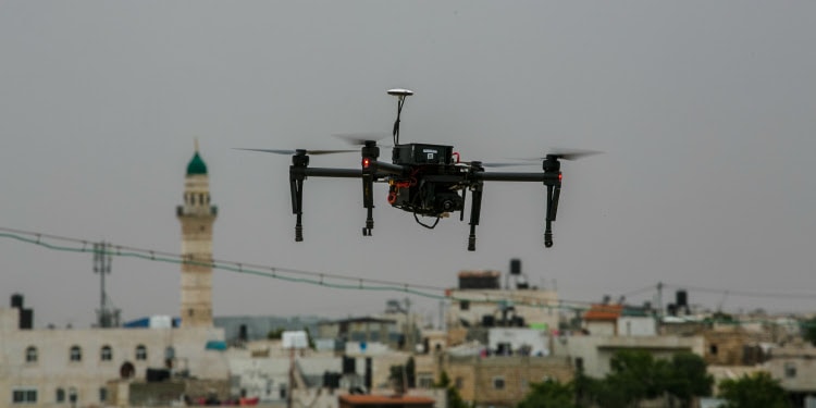 Close up image of a security drown flying over a town.