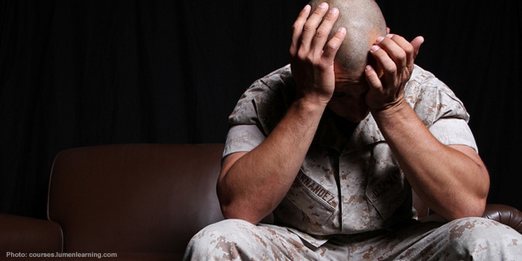 Man sitting with his hands in his head depressed.