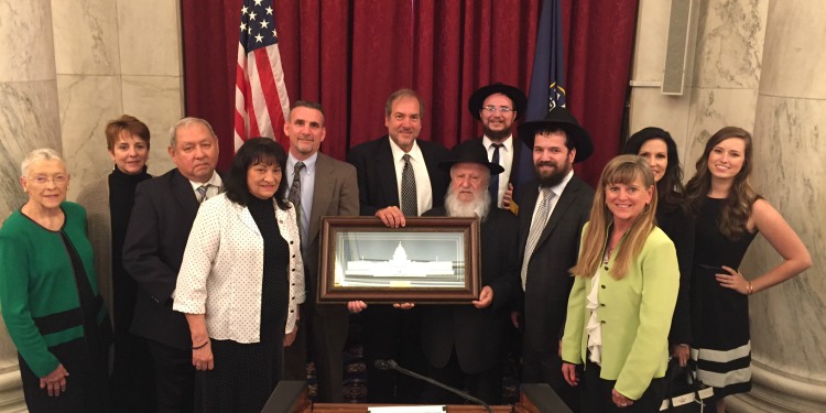 Several donors standing together holding a framed picture of the Capitol.