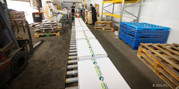 ESHEL Chabad warehouse workers packaging food boxes for potential emergency situation with Iran.