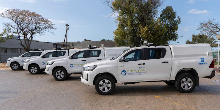 Four IFCJ vans parked in a diagonal line.