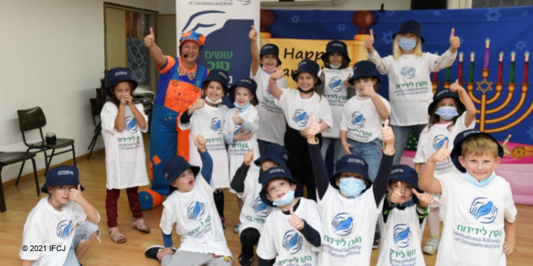 Gathering of children in white IFCJ t-shirts for Hanukkah in 2021.