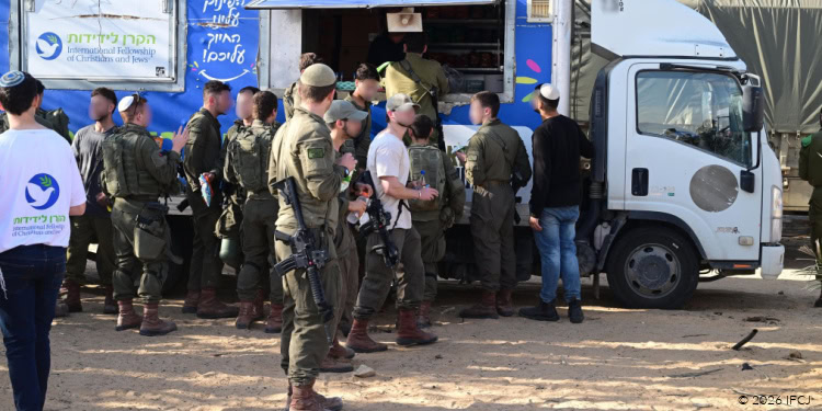 IDF reservists gather around a mobile distribution truck receiving thank-you letters and support from civilians during a community event.