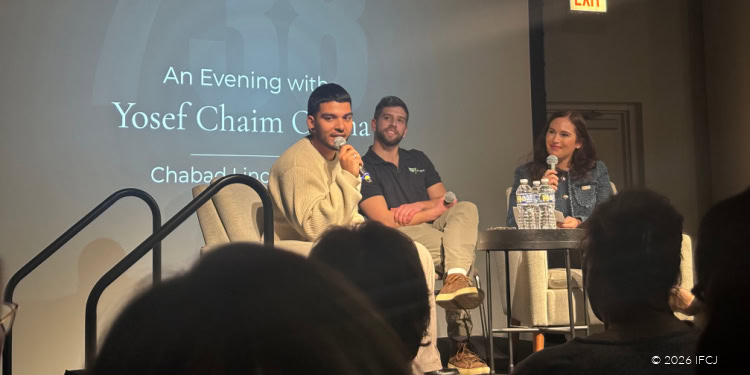 Yosef Chaim speaking at IFCJ event during an evening discussion on community support and charity initiatives.