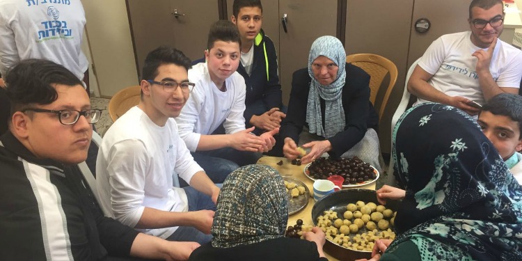 IFCJ volunteers making Easter cookies for elderly Christians.