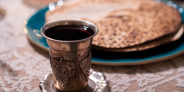 Passover wine in cup with matzah on a plate.
