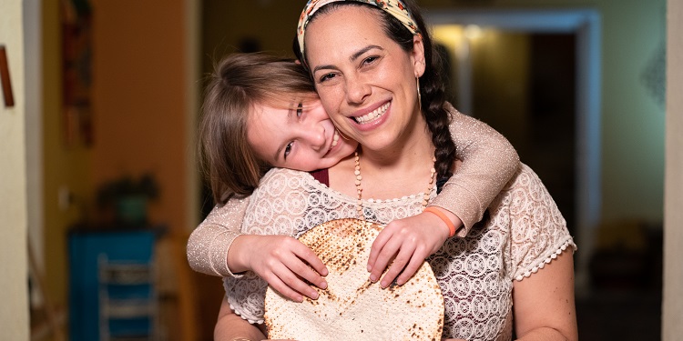 Yael Eckstein and her daughter Sapir hugging while holding matzah.