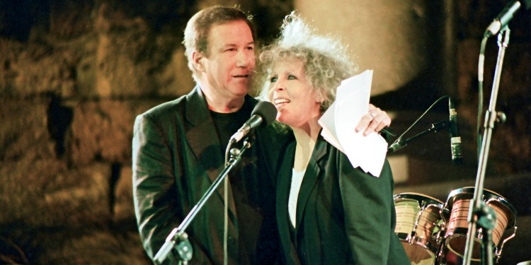 Couple on stage singing alongside one another.