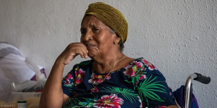 Sad elderly Jewish woman sitting in wheelchair crying.