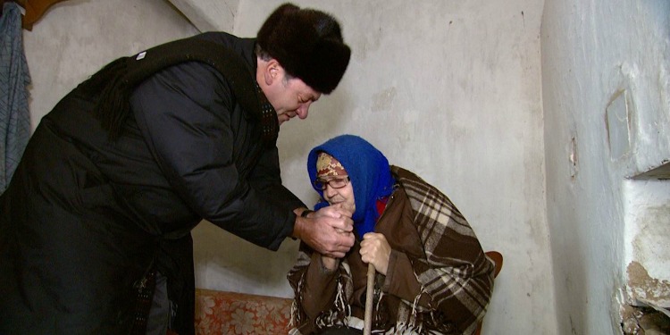 An elderly Jewish woman kissing Rabbi Eckstein's hands.