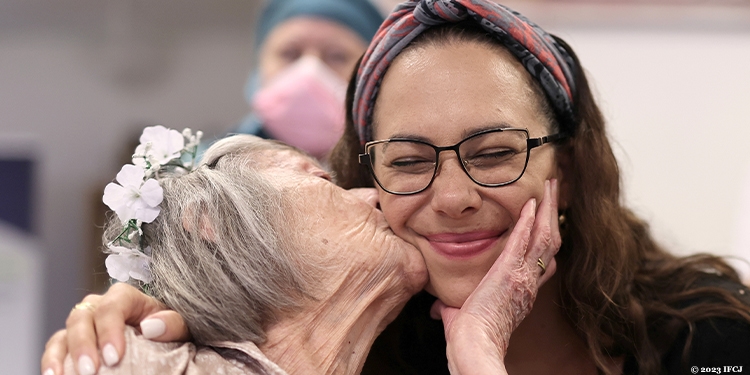 Elderly woman kissing Yael.