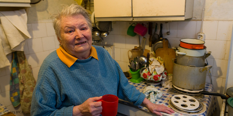 Elderly woman standing in her kitchen