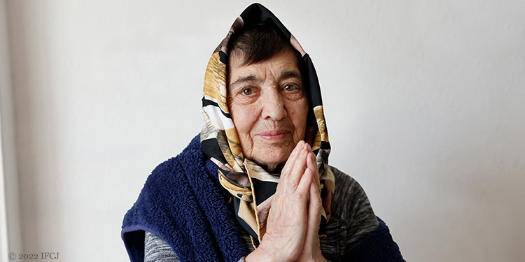 Elderly woman with praying hands