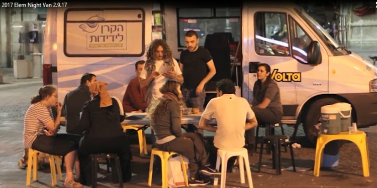 A group of nine outside of an IFCJ branded van helping at risk youth.