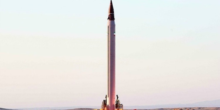 A large missile against a blue and purple background.
