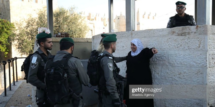 Woman talking to several soldiers.