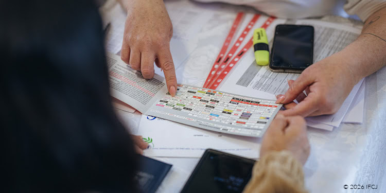 Emergency Purchase Cards for Beit Shemesh Evacuees - Iran Conflict - Jerusalem, Israel - March 17, 2026 hands only - woman with pink nails holding open a booklet and pointing at information - cell phone - yellow highlighter