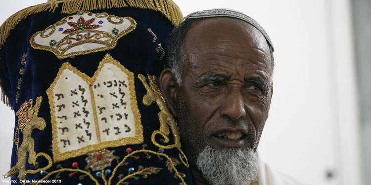 Ethiopian man carrying a spiritual object, while looking to his left.