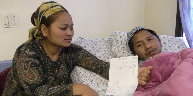 A woman sitting next to a car ramming victim who's recovering in bed.