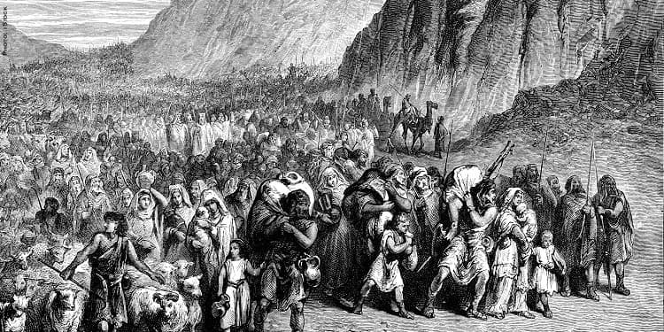 Black and white image of several people gathering next to mountains.