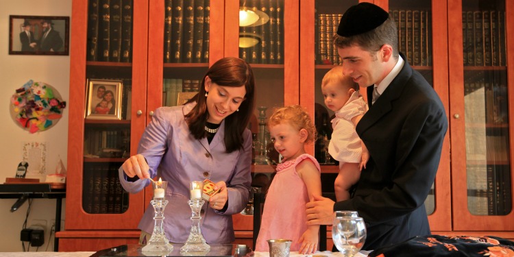 Mother of a family lighting Sabbath candles.