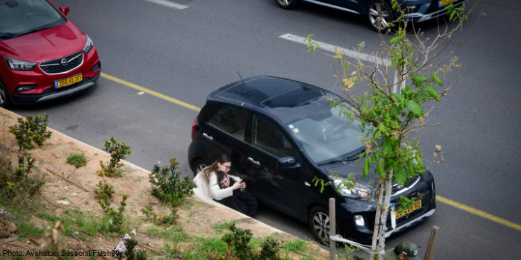 Israelis take cover on Ayalon highway as siren alerts are sounded in Tel Aviv, March 20, 2025.