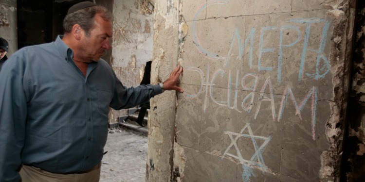 Rabbi Yechiel Eckstein, graffiti on wall says 