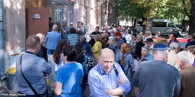 FJC distribution of Rosh Hashanah food boxes. crowd of people standing outside of FJC warehouse
