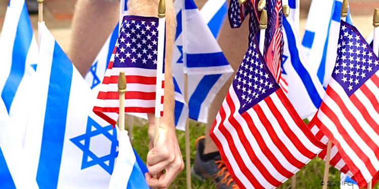People holding Israeli and American flags during a celebration event, showcasing national pride and unity.