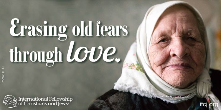 IFCJ promotion featuring a smiling old woman with the text: Erasing old fears through love.