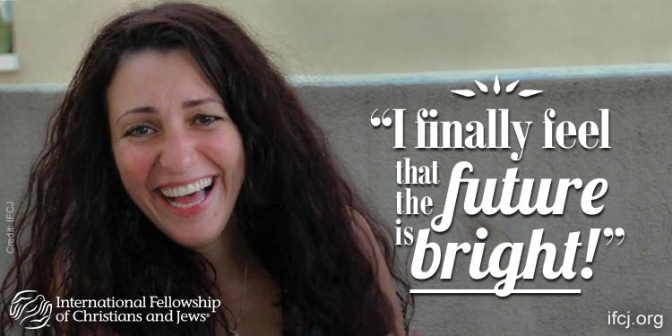 Limor, an IFCJ recipient with long brown hair and laughing while featured in an IFCJ promotion.
