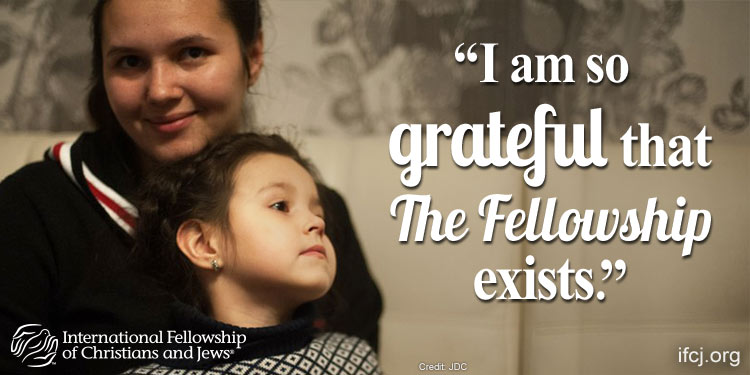 Mother and daughter Ulyana and Sasha sitting together in dark sweaters while being featured in an IFCJ promotion.