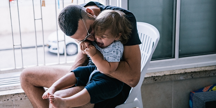 Father sitting in chair holding young boy-14670351