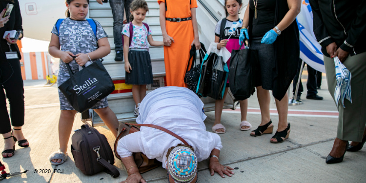 Woman kissing the ground after the Aliyah flight.