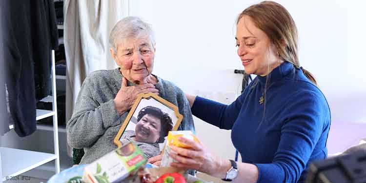 Fellowship volunteer sitting with elderly woman