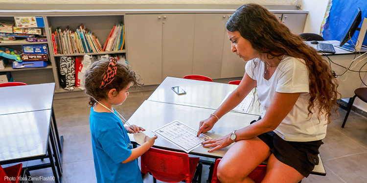 First grader sitting with the teacher