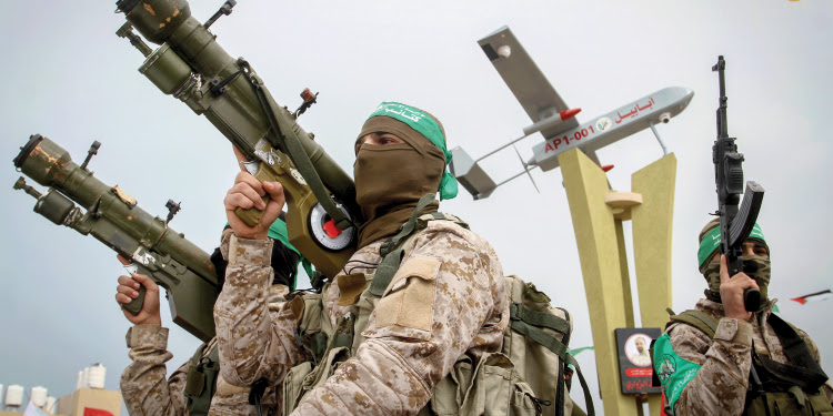 Three soldiers in uniform holding fire arms.