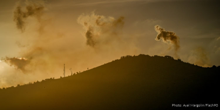 Sunset over a mountain with a dramatic sky and scattered clouds, highlighting hope and resilience.