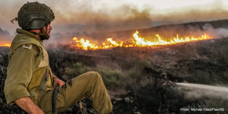 Israeli Security forces try to extinguish a fire near the scene of where a rocket fired from Lebanon hit a car and critically injured two people near Nafah Junction, in the Golan Heights, July 9, 2024.