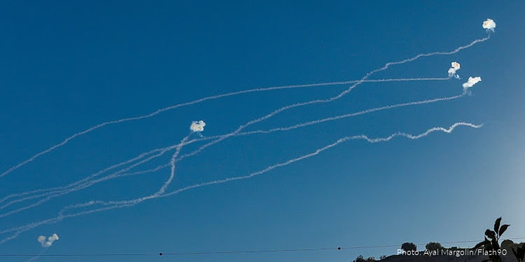 Israeli military aircraft launching missiles with trails in the sky during a strike against Hezbollah targets.