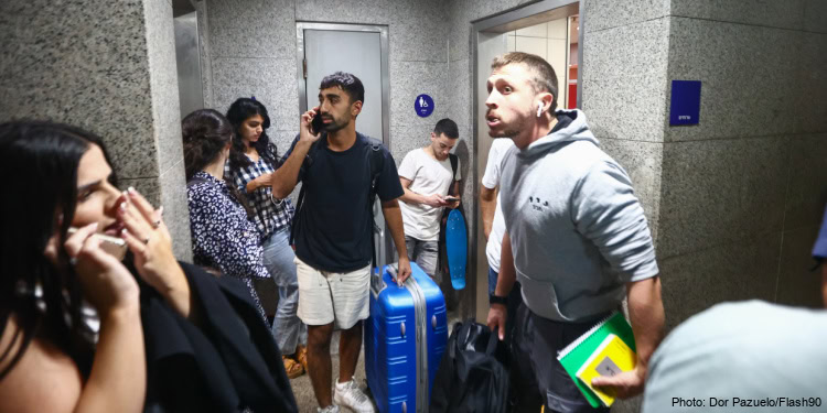 Israelis take cover inside a bomb shelter at the Ben Gurion airport as a siren alert is sounded in Tel Aviv, October 1, 2024.