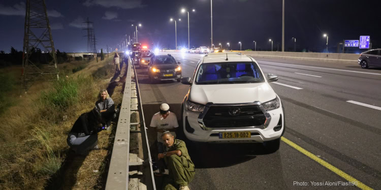 Israelis take cover by the side of a road as siren alerts are sounded in central Israel, October 1, 2024. (Photo: Yossi Aloni/Flash90)