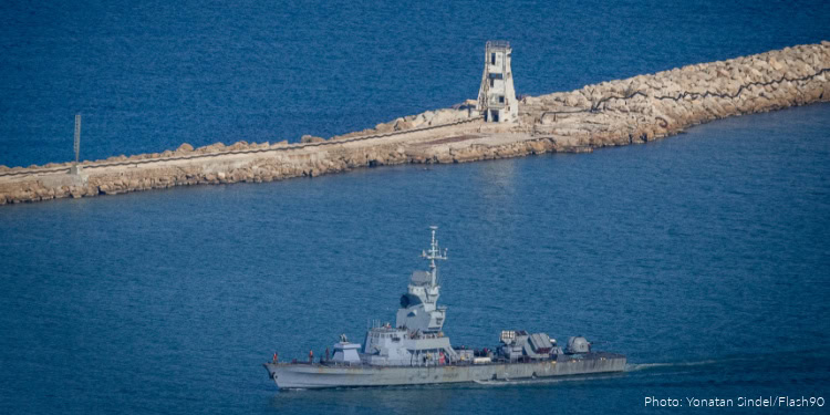 Supportive military ship navigating near a breakwater with a lighthouse, illustrating maritime security and aid efforts.